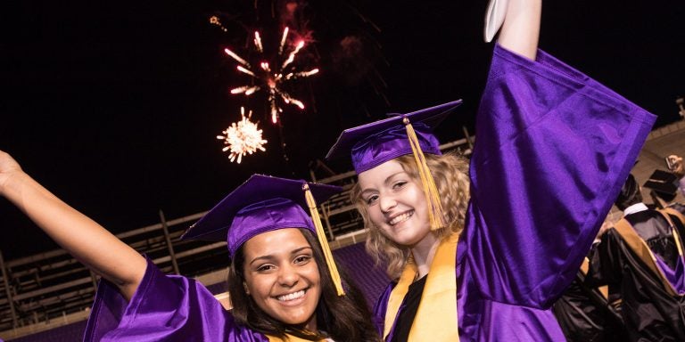 ECU students celebrate under the fireworks at commencement.