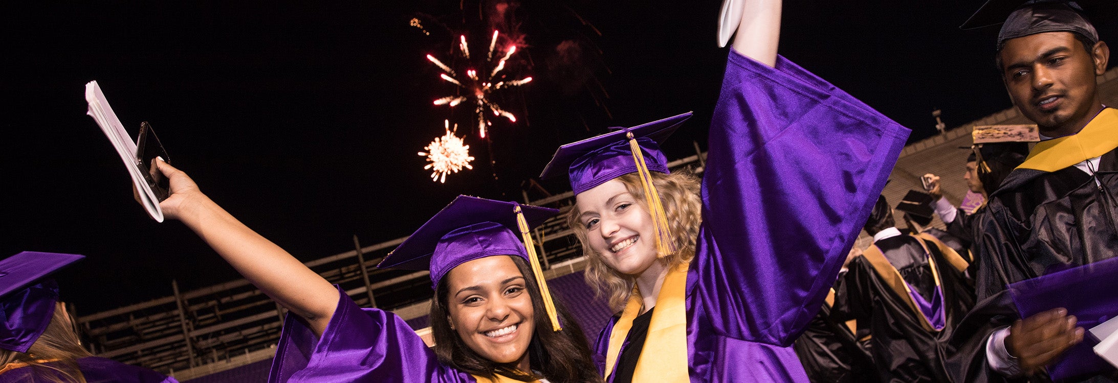ECU students celebrate under the fireworks at commencement.