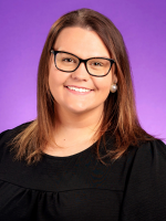 A female with brown hair in a black top and glasses